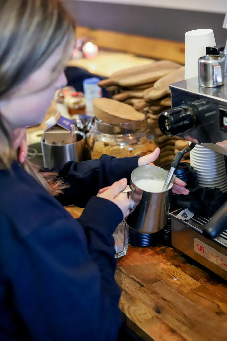 Barista stoomt melk voor koffie bij MILK Barista stoomt melk voor koffie bij MILK